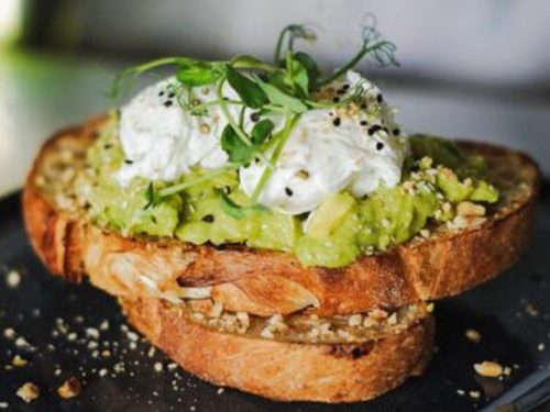 Smashed Avo & Eggs sandwich ($16) from Riders Cafe has poached eggs atop a blanket of avocado, with a sprinkling of crushed hazelnuts (high in Vit E, also a brain food!), delivered islandwide in Singapore powered by Oddle
