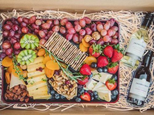 Gourmet cheese and fruit platter with grapes, kiwi, dried apricots, strawberries, blueberries, crackers and cheese. With two small bottles of wine. All delivered in a carton box for convenient sharing platters, sent islandwide in Singapore, powered by Oddle